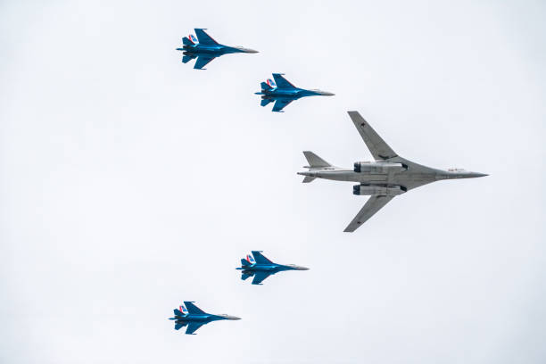 The Tu-160 strategic missile carrier, accompanied by four Su-35S fighter jets, flies over Red Square during the May 9 parade in Moscow. Moscow, Russia - May, 09, 2021: The Tu-160 strategic missile carrier, accompanied by four Su-35S fighter jets, flies over Red Square during the May 9 parade in Moscow. tu160 stock pictures, royalty-free photos & images