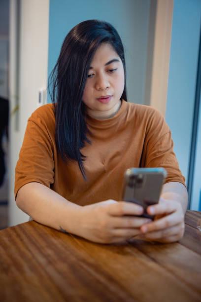 istock Woman texting on her smart phone at the table in cafeteria 1349103737