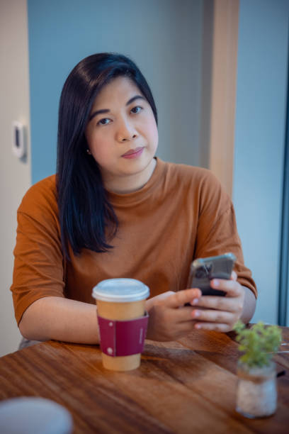 istock Woman using her smart phone on coffee break at the table in cafeteria 1349103739