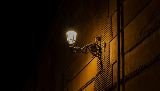 Street lamp on a brick wall at night