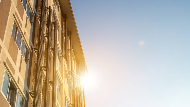 Modern apartment building on a sunny day. Architectural details and facade of a modern apartment building. Red sun on horizon
