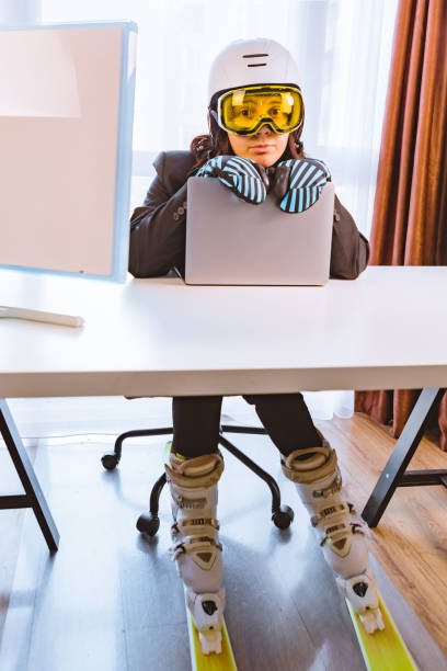 woman in ski equipment working on laptop in office stock photo