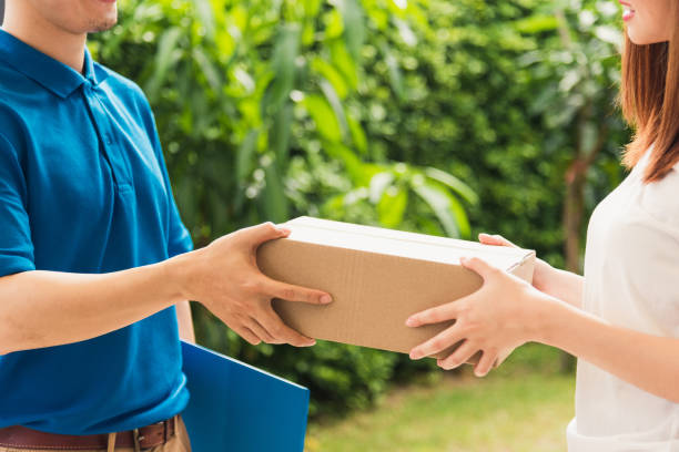 istock delivery man courier in uniform hold parcel post boxes service shipment woman customer 1349112625
