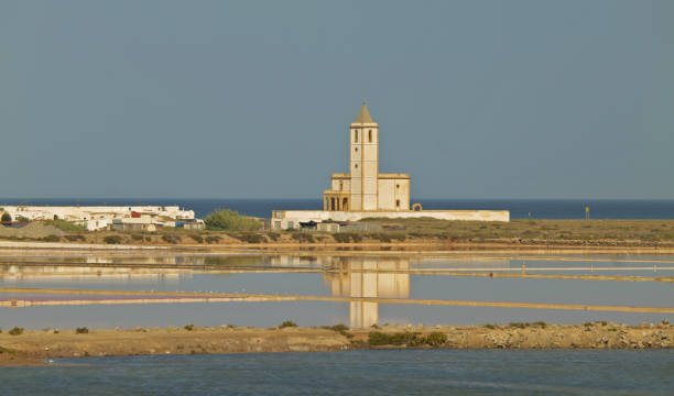 istock Church building on beach in sunny day and reflection on water 1349112907