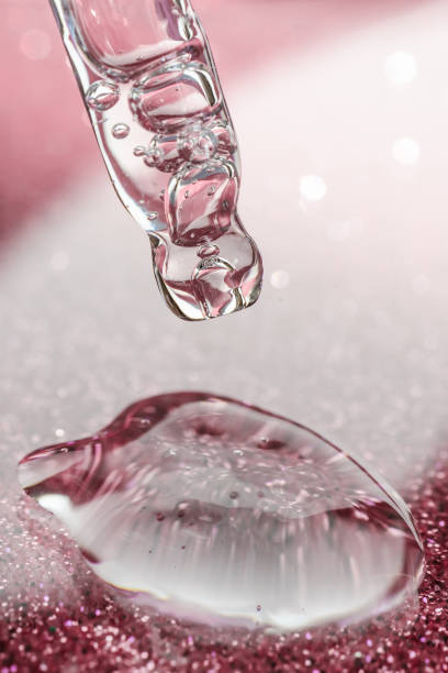istock Cosmetic pipette with a pink on dark background. 1349115356
