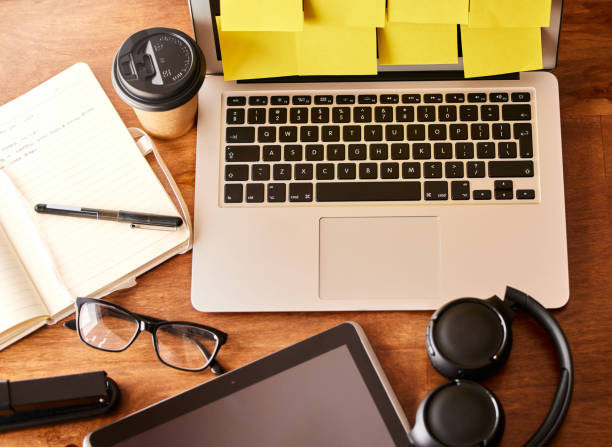 scatto di un ufficio vuoto con un laptop, tablet digitale e set di cuffie sulla scrivania - neat good condition studio shot still life foto e immagini stock