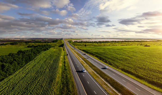 istock Aerial view of a highway going through agricultural fields at sunset 1349120323