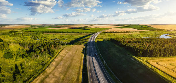 istock Aerial view of a highway going through agricultural fields at sunset 1349121051