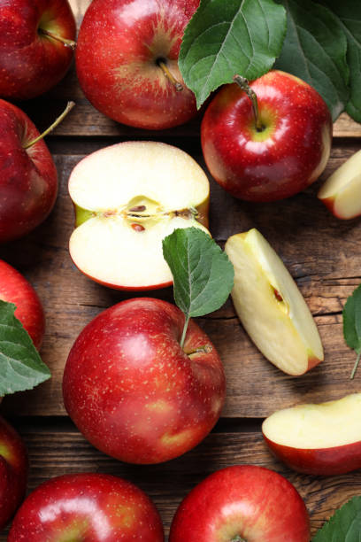 Ripe juicy red apples on wooden table, flat lay