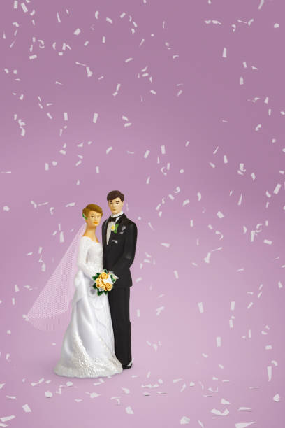 istock bride and groom wedding cake toppers with confetti falling 1349122802