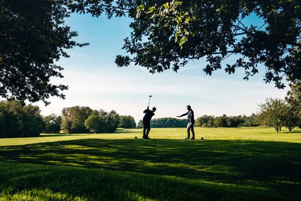 Entraîneur de golf donnant une leçon. - Photo