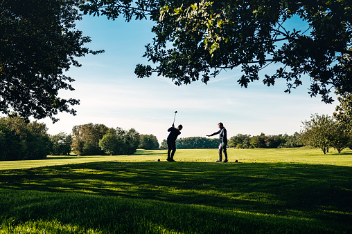 Golf coach giving some tips to his pupil. Shot on location on the island of Moen in Denmark. Colour, horizontal format with some copy space.