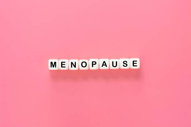 istock Menopause word abstract text, wooden blocks over pink background 1349131389