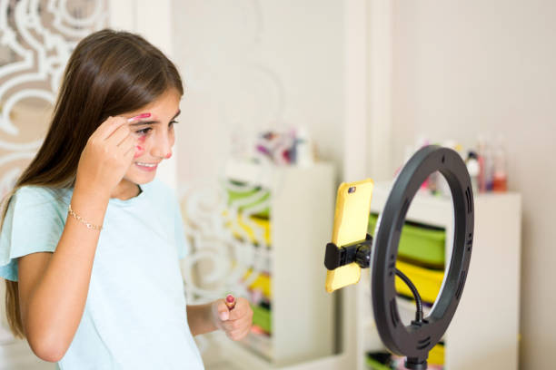 istock Cute girl fixing make up to live broadcast 1349133077