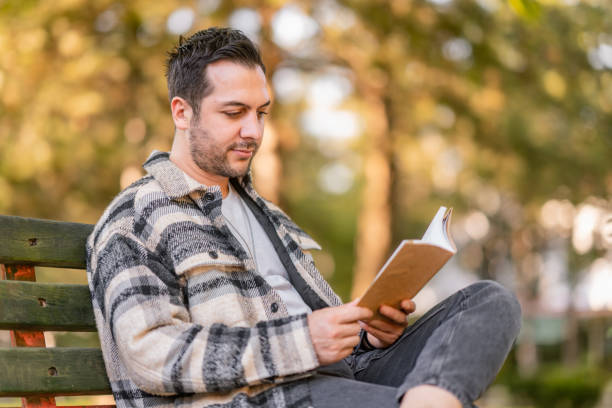 bell'uomo che si rilassa e legge il libro nella natura - men reading outdoors book foto e immagini stock