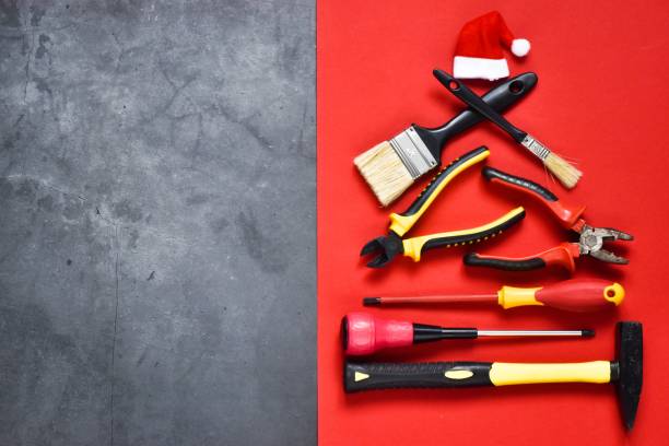 istock Creative Christmas tree made of construction tools on a grayand red background with santa claus hat 1349134153