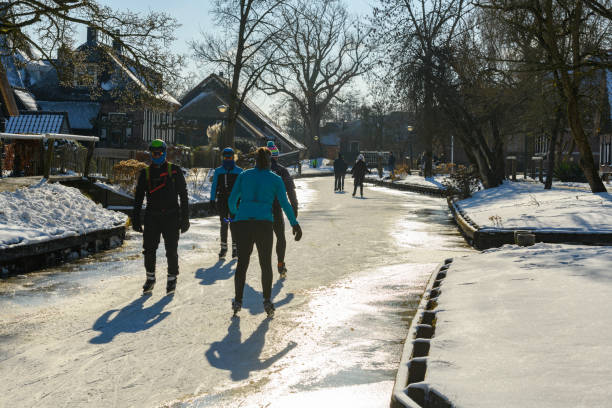 persone che pattinano sul ghiaccio nel weerribben wieden durante una bella giornata invernale - wieden weerribben foto e immagini stock