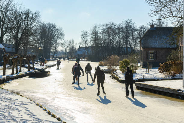 persone che pattinano sul ghiaccio nel weerribben wieden durante una bella giornata invernale - wieden weerribben foto e immagini stock