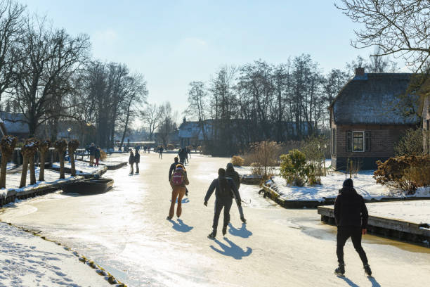 gente patinando sobre hielo en el weerribben wieden durante un hermoso día de invierno - wieden weerribben fotografías e imágenes de stock