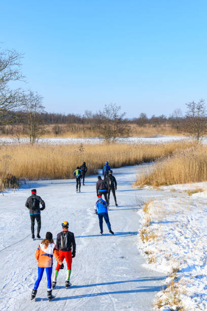 gente patinando sobre hielo en el weerribben wieden durante un hermoso día de invierno - wieden weerribben fotografías e imágenes de stock