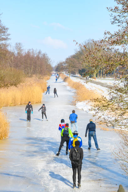 gente patinando sobre hielo en el weerribben wieden durante un hermoso día de invierno - wieden weerribben fotografías e imágenes de stock