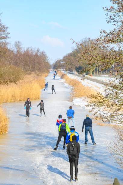 persone che pattinano sul ghiaccio nel weerribben wieden durante una bella giornata invernale - wieden weerribben foto e immagini stock