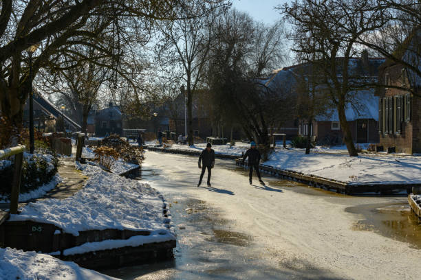 gente patinando sobre hielo en el weerribben wieden durante un hermoso día de invierno - wieden weerribben fotografías e imágenes de stock