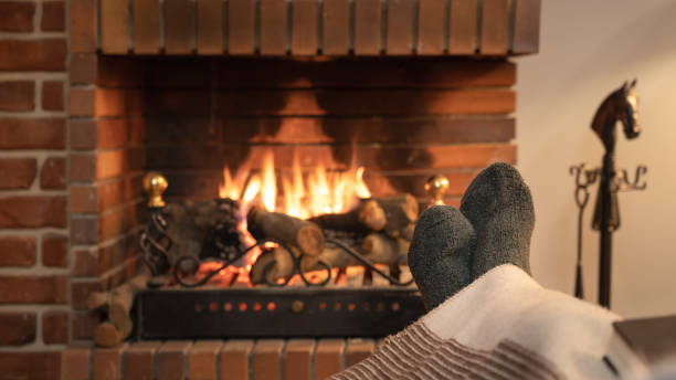 les pieds dans les chaussettes devant le feu d’une cheminée en hiver. - blanket fireplace winter women photos et images de collection
