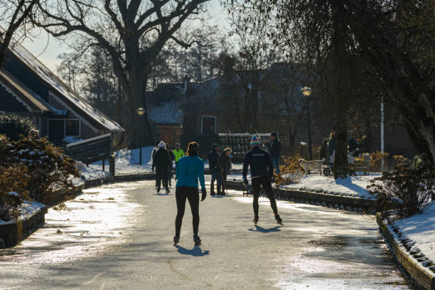 gente patinando sobre hielo en el weerribben wieden durante un hermoso día de invierno - wieden weerribben fotografías e imágenes de stock