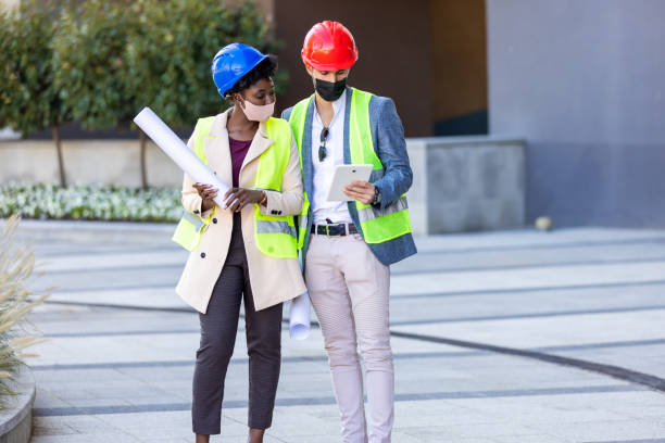 istock Construction manager and engineer with face masks and helmets working on the construction site 1349137893
