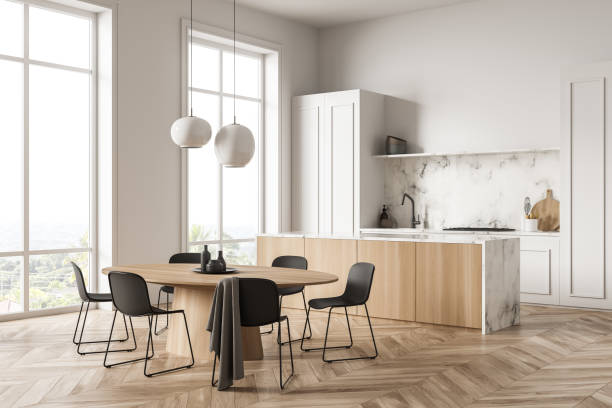 istock Minimalist white kitchen space with wood materials and black chairs. Corner view. 1349137935