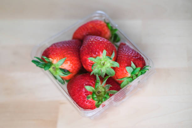 istock Fresh red strawberries in plastic container box on wood table 1349138027