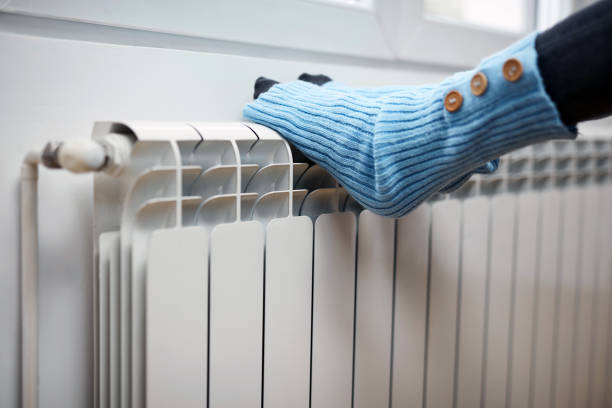 istock Woman's feet with woolen socks, enjoying inside home on the radiator. 1349142013