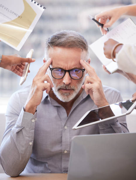 Cropped shot of a handsome mature businessman looking stressed while being presented with multiple tasks at his desk in the office