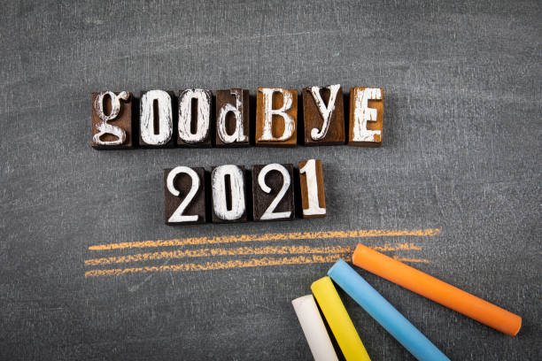 istock Goodbye 2021. Text and colored pieces of chalk on a blackboard 1349150438