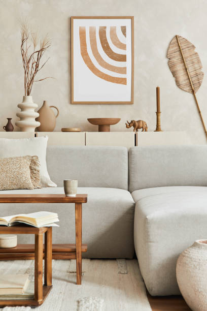 istock Elegant living room interior design with mock up poster frame, grey corner sofa, coffee table and personal accessories. Pastel neutral colours. Template. 1349153111