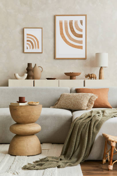 Elegant living room interior design with mock up poster frame, grey corner sofa, coffee table and personal accessories. Pastel neutral colours. Template. stock photo