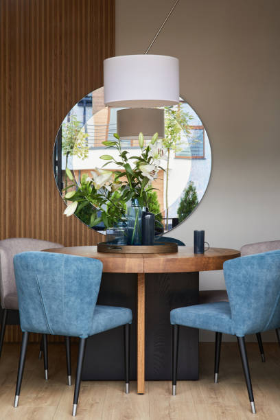 istock Elegant dining room interior composition with velvet armchairs, design rounded wooden table and beautiful personal accessories. Glamour interior design inspiration. Details. Template. 1349155335