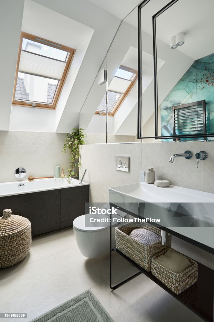 Stylish bathroom design with panels painted in green on the wall. Bathtub, towels, rattan baskets and other personal accessories. Glamour interior concept. Template. Domestic Bathroom Stock Photo
