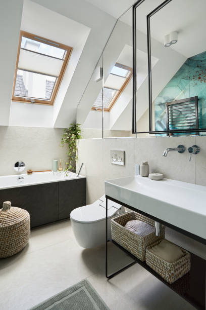 стильный дизайн ванной комнаты с панелями, окрашенными в зеленый цвет на стене. ванна, полотенца, ротанговые корзины и другие личные аксесс� - величественное жилище стоковые фото и изображения