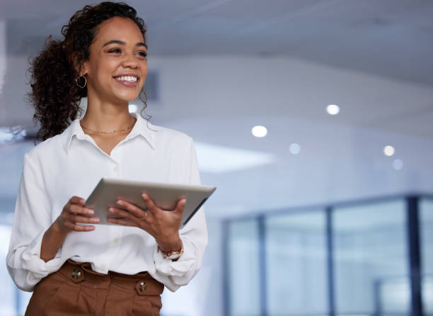 photo d’une jeune femme d’affaires utilisant une tablette numérique au travail - technology contemplation clothing formalwear photos et images de collection