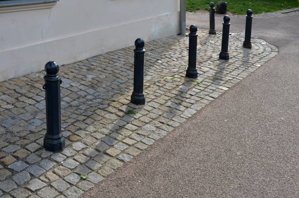 Balustrade near the castle in the autumn sun, yellow maple leaves. wooden bench. metallic dividing posts and bollards with a sea-themed wave. protected from the wheels of carriages Balustrade near the castle in the autumn sun, yellow maple leaves. wooden bench. metallic dividing posts and bollards with a sea-themed wave. protected from the wheels of carriages, acer, platanoides, street post stock pictures, royalty-free photos & images