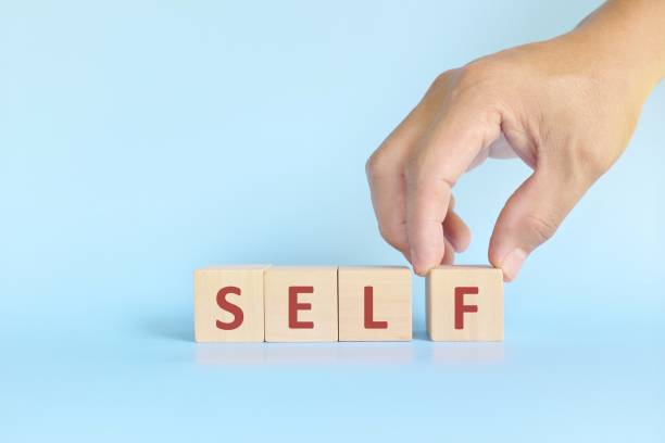 istock Build, complete self, self fulfilment and development and management concept. Hand stacking wooden blocks with word self. 1349161068