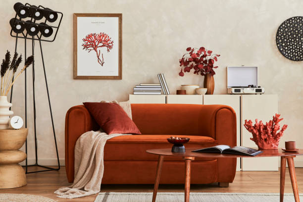 istock Creative composition of stylish living room interior with mock up poster frame, orange sofa, beige commode, coffee table and stylish personal accessories. Artistic space. Template. 1349162506