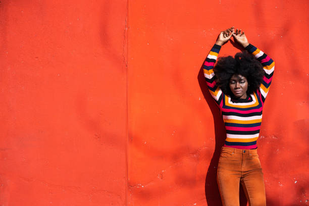 istock Smiling american-african woman standing on a red background 1349164152