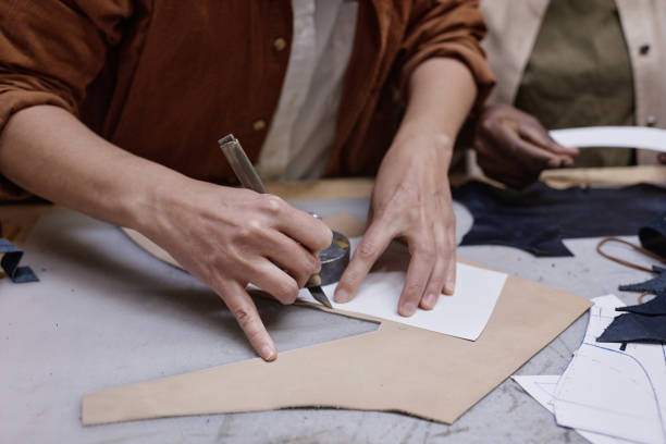 istock Dressmaker cutting the fabric at the table 1349164357