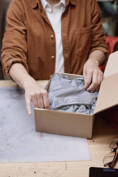 istock Woman packing parcel for delivery 1349164438