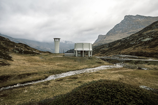 concrete ventilation shaft towers of the San Bernardino Tunnel system on meadow alongside the pass road in the Swiss alps in the Graubünden canton