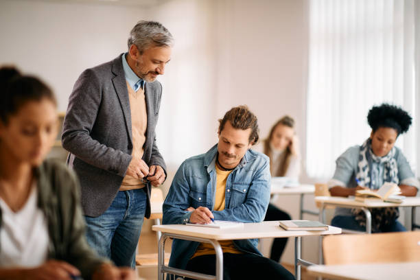 istock Mature professor assisting his student with lecture during a class in the classroom. 1349165802