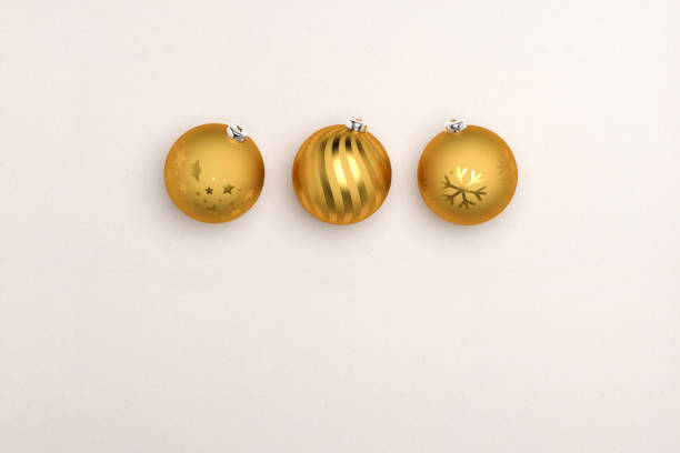 Three golden christmas baubles on paper background. Copy space below for your own message.